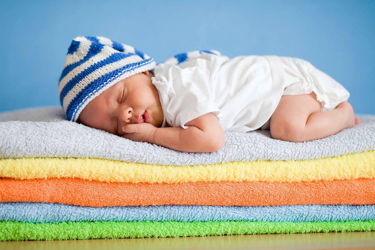newborn baby asleep on towels